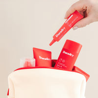 Hand dropping the Duradry Sweat Minimizing Gel into the cream Travel Bag